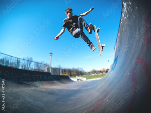 Zdjęcie XXL Skateboarder robi ollie na rampie