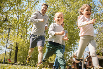 Cheerful father playing with his children's.