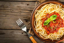 Italian Cuisine. Lunch Or Dinner. A Serving Of Spaghetti Pasta With Tomato Marinara Sauce And Basil On A Dark Wooden Table. Copy Space Top View