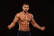 © satyrenko - Strong Athletic Man Fitness Model Torso showing six pack abs. isolated on black background with copyspace