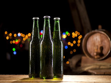 Glass Bottles Of Beer And Wooden Barrel On Bar Lights Background