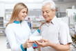 © Nestor - Young female pharmacist helping an elderly customer