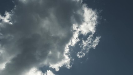 Wall Mural - Time lapse on bright sunny blue sky revealing as passing dark cloud moves through the mid day sky.