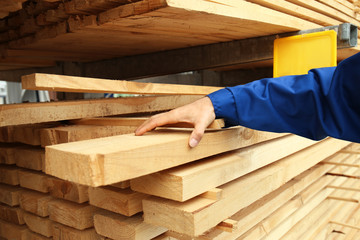 Canvas Print - Carpenter with wooden planks in workshop, closeup