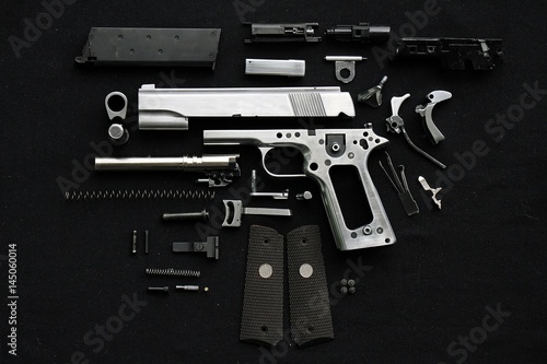 Fotomural Disassembled handgun on black background,