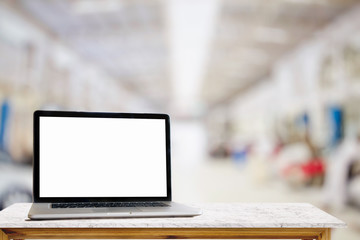 Wall Mural - Laptop with blank screen on top table for product or graphic display  montage in garage car service center background.