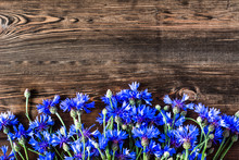 Floral Frame With Blue Flowers Selected On Wooden Background