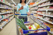 © Syda Productions - woman with smartphone buying food at supermarket