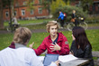 © Astrakan Images - Young friends discussing while sitting at table in campus