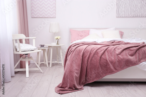 Comfortable Bed With Soft Pink Coverlet Pillows And Chair