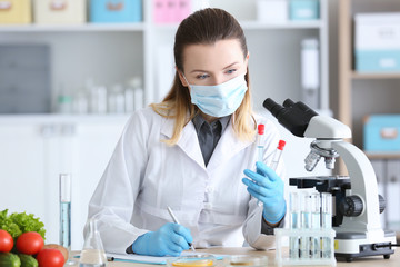 Wall Mural - Young female nutritionist testing food samples in laboratory