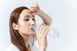 © metamorworks - hydration concept. a young woman drinking a bottle of water.