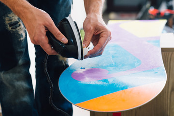 man is waxing a snowboard