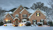 © clsdesign - Beautiful brick estate home exterior in snow decorated for the holidays