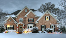 Beautiful Brick Estate Home Exterior In Snow Decorated For The Holidays