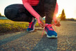 © vladstar - Running shoes - woman tying shoe laces
