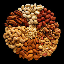 Assorted Nuts In The Form Of A Circle (peanuts, Almonds, Hazelnuts, Pine Nuts, Cashews, Walnuts, Pistachio) Isolated Against The Black Background.
