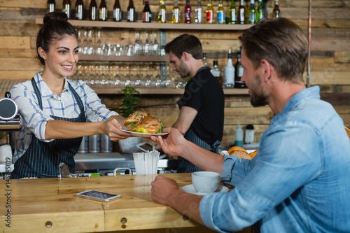 Fotomural Waitress serving breakfast to man at counter