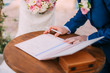 Newlyweds put their signatures in the act of registering a marriage at a wedding ceremony in Montenegro.