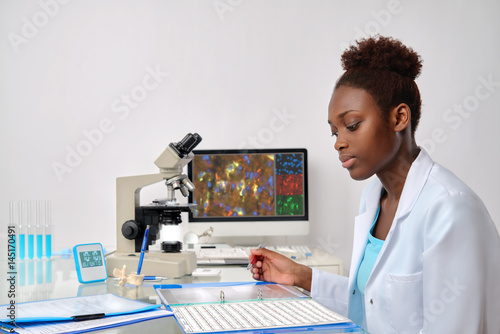 Fotomural African-american biologist checks sequencing records