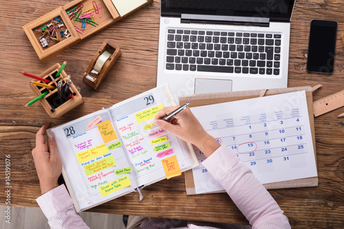 Cuadros en Lienzo Businesswoman Writing Schedule In Calendar Diary