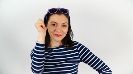 Wall Mural - A model with dark hair, 30-35 years old, tries on sunglasses and poses on camera.