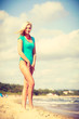 © Voyagerix - Woman walking on beach wearing swimsuit