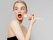 © looking2thesky - Beautiful blonde girl with red lips and manicured nails eating sushi, healthy japanese food. Beautiful woman holding chopsticks with sushi. Sexy lady