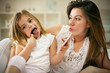 © liderina - Smiling mother with daughter using smart phone on bed.