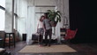 © vadim_key - Multiethnic couple gather in travel. Woman holds suitcase, man holds plant. Boy and girl kisses and goes away.