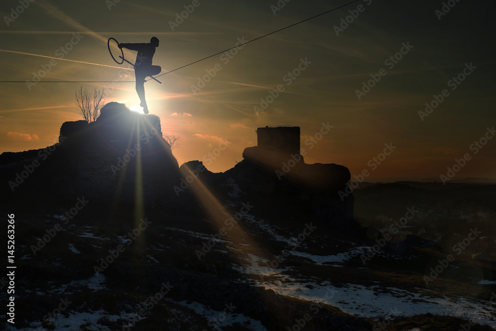 Człowiek na linie na zamku w Olsztynie o zachodzie słońca. - obrazy, fototapety, plakaty 