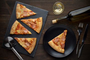 Wall Mural - Fresh hot hawaiian pizza ready to eat with wine on wooden table.