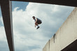 © Coka - young man doing parkour jump  in the city