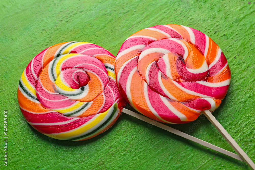 Tasty lollipops on color wooden background, closeup