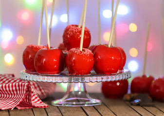 Poster - Delicious toffee apples on glass stand against fuzzy background