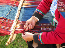 Close Up Of Peruvian Lady In Authentic Dress Spinning Yarn By Hand