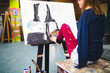 Disabled beautiful young artist painting incredible scenes in attic by holding paintbrush in her toes. Selective focus. 