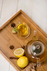 Wall Mural - Cup of ginger tea with lemon and honey on white wooden background.