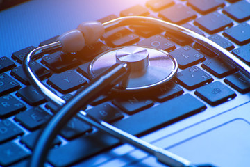 Computer or data analysis - Stethoscope over a computer keyboard toned in blue
