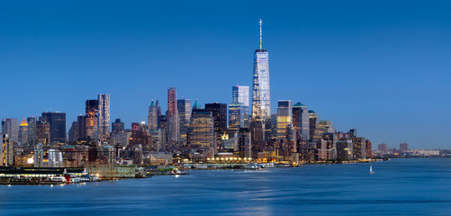 Fototapete - New York City Lower Manhattan at dusk. The panoramic view includes the skyscrapers of the Financial District and the Hudson River