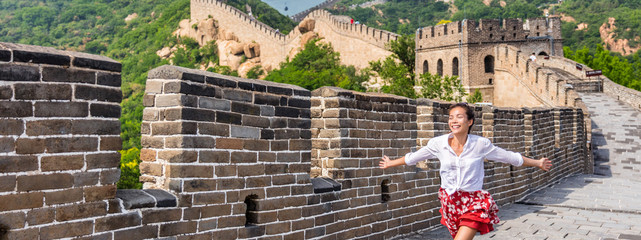 Wall Mural - Happy carefree woman traveler running free on Great wall of china. Asia travel. Summer destination popular tourist attraction.