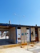 Heruntergekommene öffentliche Toiletten vor blauem Himmel im Sonnenschein an der Uferpromenade am Yachthafen von Alacati bei Cesme am Ägäischen Meer in der Provinz Izmir in der Türkei