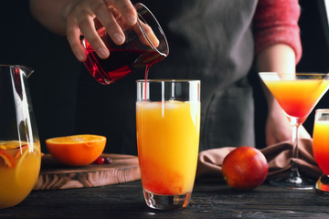 Poster - Woman making tequila sunrise cocktail in bar