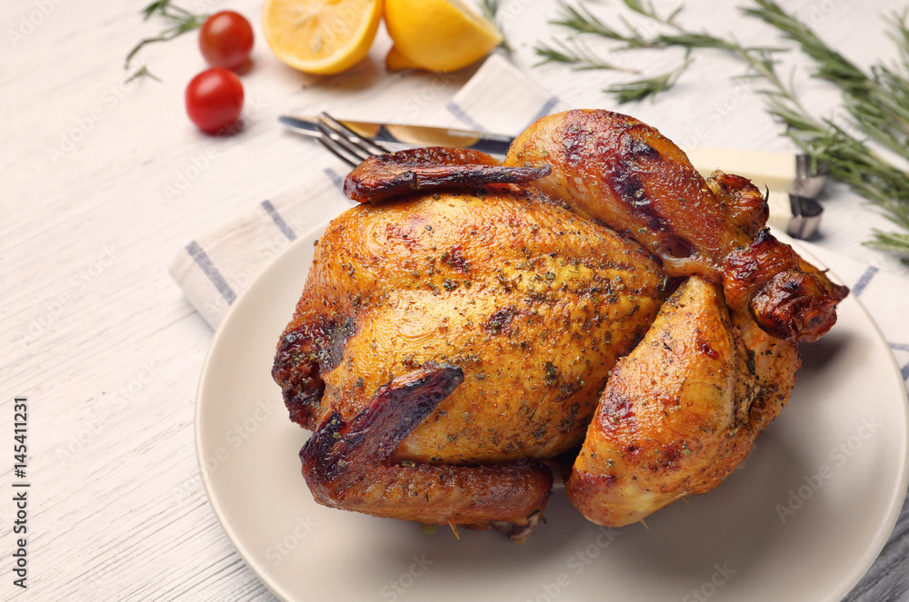 Plate with roasted beer can chicken on table