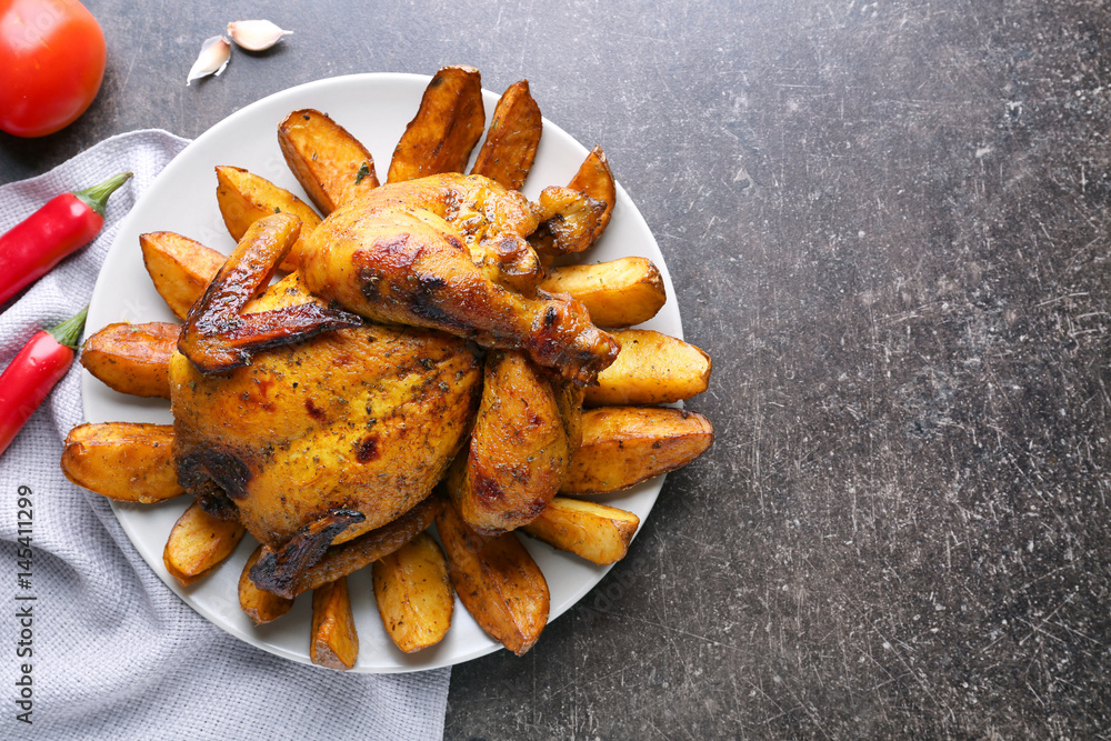 Plate with roasted beer can chicken on gray table