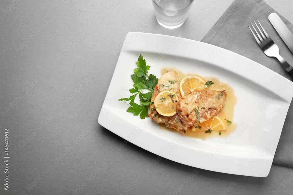 Plate with tasty Italian chicken piccata on table