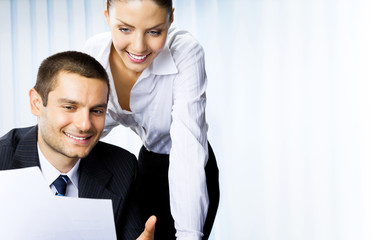 Two businesspeople working with document at office