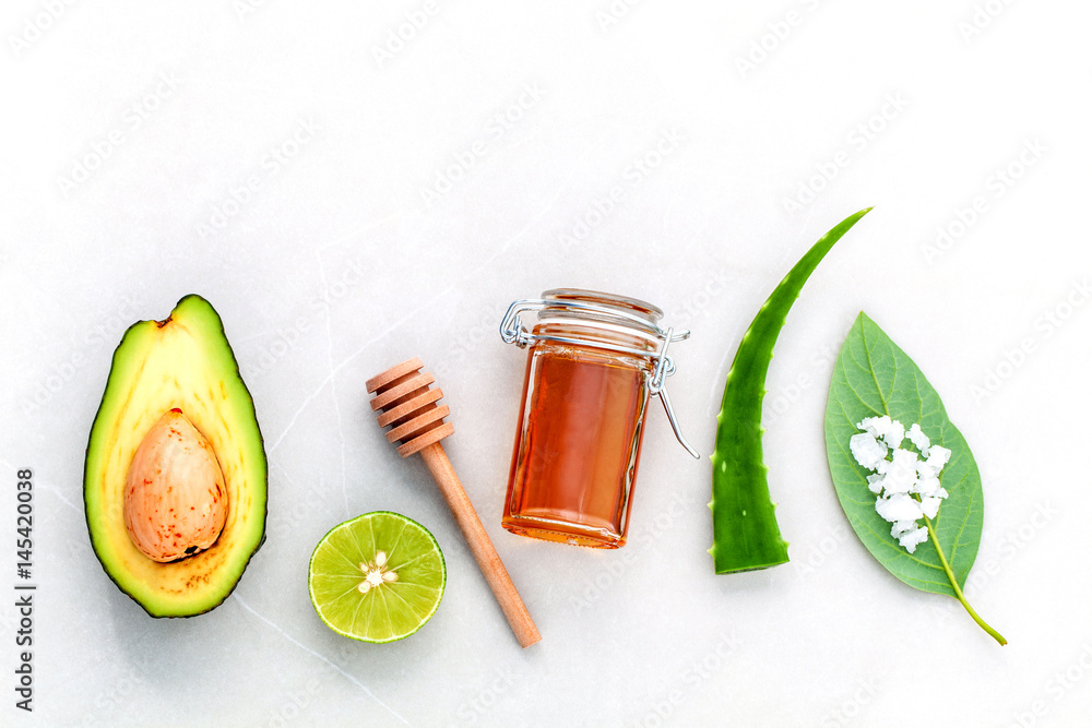 Homemade skin care and body scrub with natural ingredients fresh  avocado , leaves ,sea salt , lime and honey on marble background  with flat lay. - obrazy, fototapety, plakaty 