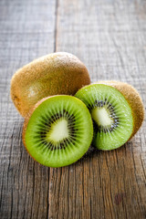 Wall Mural - Fresh green healthy kiwi fruits and sliced on wooden table background