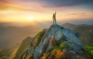 Wall Mural - tourist on the peak of high rocks. sport and active life concept